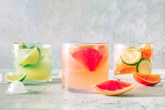 Refreshing summer cocktails with ice cubes on a light background