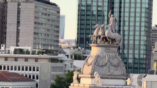 Majestic quadriga statue on the rooftop of a building contrasting with the modern architecture of Madrid's skyline, highlighting the city's unique blend of historical and contemporary styles