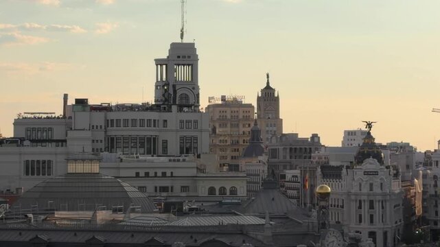 Famous Gran Via street and iconic buildings in the Madrid skyline during a warm and scenic sunset. Highlighting the capital city's unique architecture and urban landscape