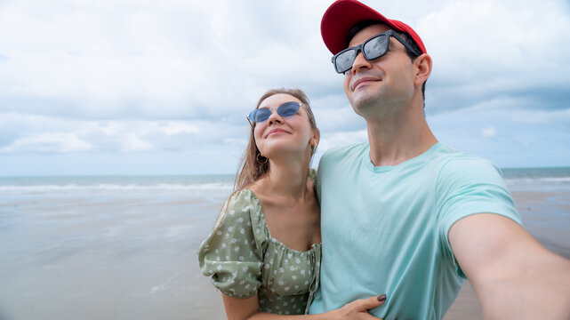 Smiling couple sharing a joyful beach holiday filled with love and togetherness. Suitable for travel advertising summer promotions and lifestyle marketing.