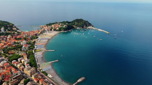 A peninsula separates two beach bays in Sestri Levante as the drone pulls back.