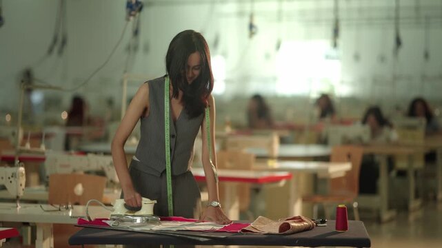 Close up of hands pinning fabric pattern pieces together preparing garment sections for sewing machine assembly process