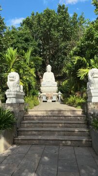 Da nang, lady buddha, white buddha statue and guardian lions creating a spiritual and serene atmosphere, surrounded by lush green foliage and blue sky
