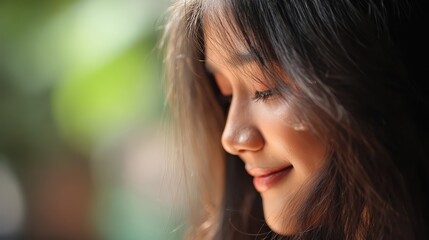 Fototapeta premium A serene young woman smiles softly in a radiant closeup portrait. Her delicate features and glowing skin evoke calm, beauty, and natural charm.