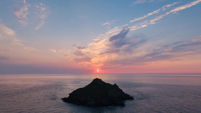 Beautiful drone landscape image of Pentire Headland and The Rumps in Cornwall and surrounding countryside during colorful Summer sunset