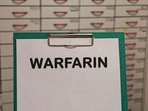 WARFARIN vitamin K antagonist anticoagulant for blood clots and stroke prevention displayed on a clipboard in a pharmacy