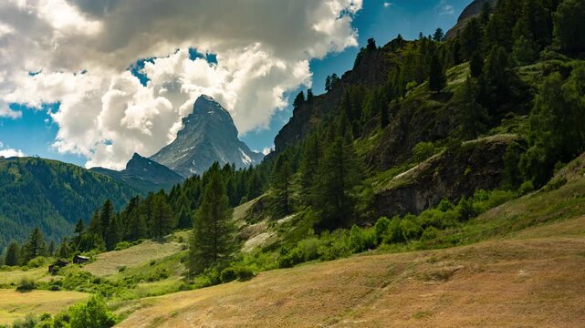 Golden hour time lapse of clouds moving over Matterhorn peak and alpine valley in Zermatt Switzerland