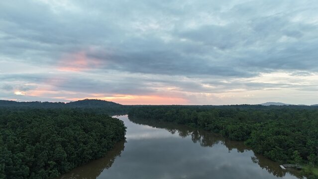 Winding tropical river through rainforest under a colorful evening sky near Roura, French Guiana.
