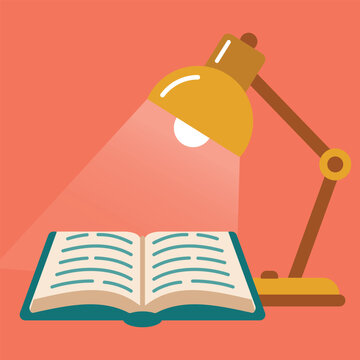 Open book on a desk illuminated by a yellow desk lamp