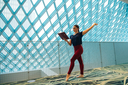 Woman practicing ballet and reading a book