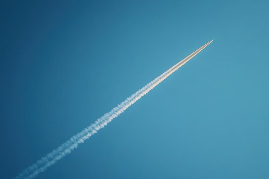 single high-altitude jet leaving a long white contrail across a clear blue sky, evoking calm and freedom