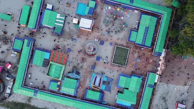 Birds eye view of a temporary carnival fairground with amusement rides and vendor stalls park festival aerial perspective overhead park festival aerial perspective overhead