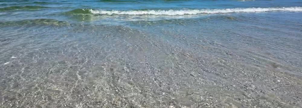 shallow slow motion wave on sand beach, natural water texture background banner for travel, vacation, beach holiday