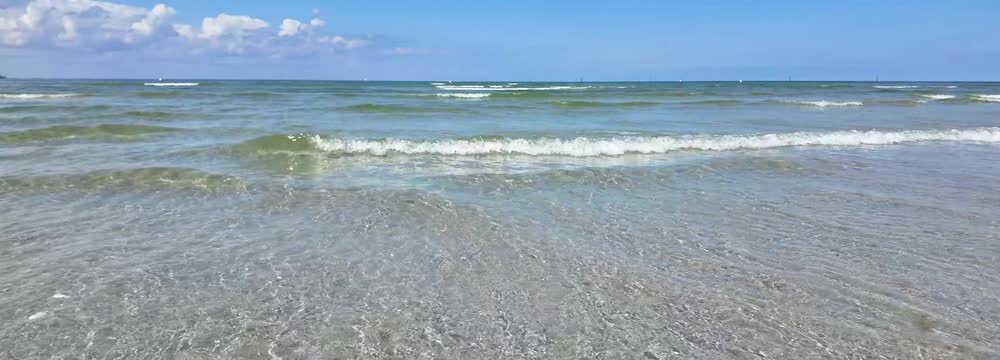 transparent slow motin wave on the sandy Baltic Sea beach, horizon over water, idyllic landscape background for travel, vacation, beach holidays, germany, stein near laboe