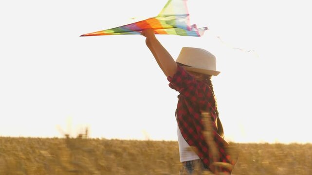 happy child kid runs through wheat field sunset. children game flying kite. catching wind with child's hand. happy family. children running through wheat field. child kid girl farmer daughter run with