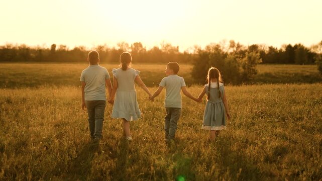 Happy children run towards sunset, girl boy holding hands run play, fun summer holidays, children recreation, laughing playful kids, positive shared path, outdoor social bonding, sharing joyful