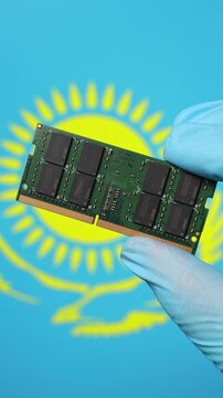 Close up view of hand in blue glove holding RAM memory microchip module. Kazakh flag in blurred background. Concept of semiconductor shortage, artificial intelligence development in Kazakhstan.