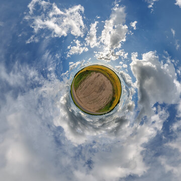 simple little tiny planet without buildings in blue sky with sun and beautiful clouds. Transformation of spherical panorama 360 degrees. Spherical abstract aerial view. Curvature of space.