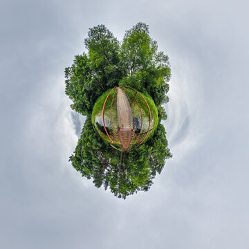 simple little tiny planet without buildings in blue sky with sun and beautiful clouds. Transformation of spherical panorama 360 degrees. Spherical abstract aerial view. Curvature of space.