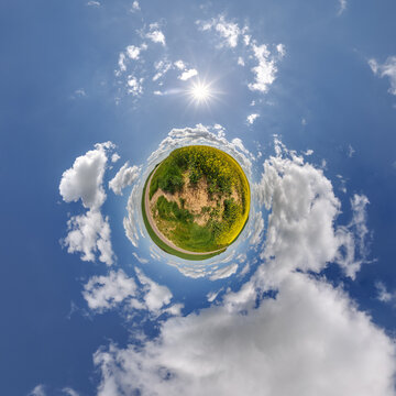simple little tiny planet without buildings in blue sky with sun and beautiful clouds. Transformation of spherical panorama 360 degrees. Spherical abstract aerial view. Curvature of space.