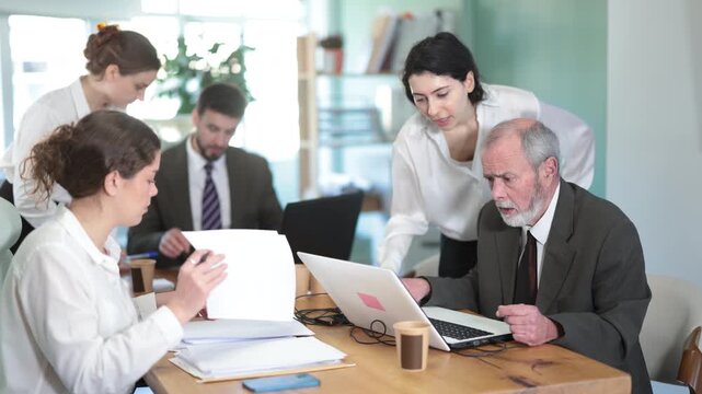 Business people working and communicating together sitting at workplace in modern office 