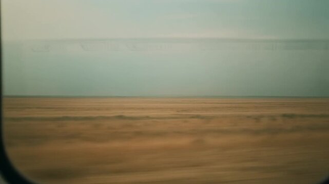 Cinematic View of Desolate Plain Landscape from Moving Train Window, Full HD Travel Background