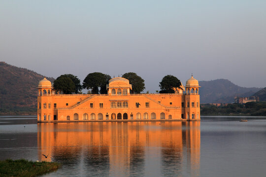 Jal Mahal reflected in the tranquil waters of Man Sagar Lake during golden hour in Jaipur, Rajasthan, India