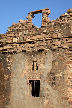Weathered stone wall ruins under a clear blue sky