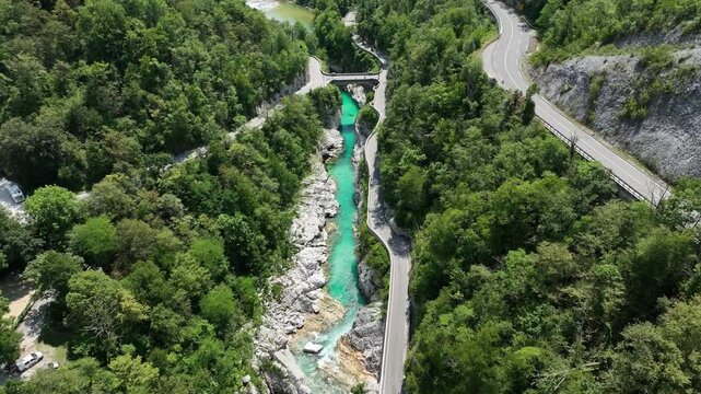 Aerial top down perspective captures turquoise Soca river crystal clear water. rocky canyon banks surrounded by dense wild green forest near Kobarid.