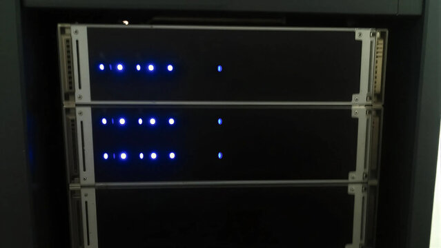 Network server rack glowing in dark datacenter room