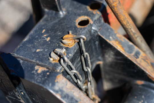 Heavy duty metal hitch assembly featuring locking mechanism pins, security cotter links, and steel chains for commercial trailer towing