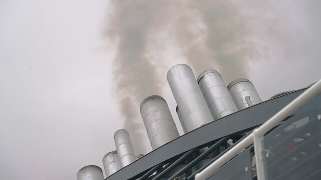 Cruiser Vessel's Smoking Chimneys Emit Plumes into Grey Sky