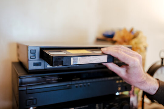 Inserting vhs cassette into vcr player for retro entertainment