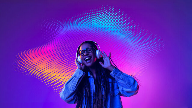 Smiling woman enjoying headphones with colorful digital sound waves. Concept of joyful music experience, streaming service advertising, music festival promotion.