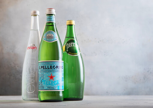 LONDON, UK - APRIL 22, 2026: Bottles of Evian San Pellegrino and Perrier sparkling and still mineral water on light table background.