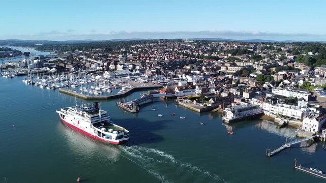 Red Funnel ferry approaching East Cowes on the Isle of Wight, England, crossing the Solent towards the ferry terminal with scenic waterfront views.