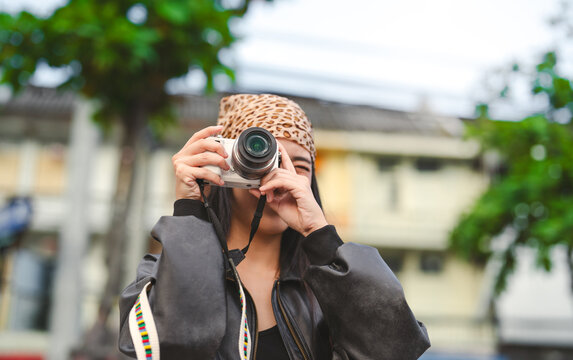 Enjoy solo young asian woman traveler hipster using digital camera take a photograph
