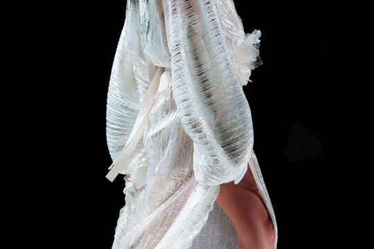 White dress with long sleeves and silver glitter on a female body