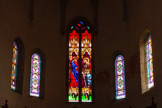 France. Lot. Saint-Cirq-Lapopie. Interior of the Church of Saint-Cyr-et-Sainte-Julitte, featuring a central stained-glass window depicting Christ as "Salvator Mundi"