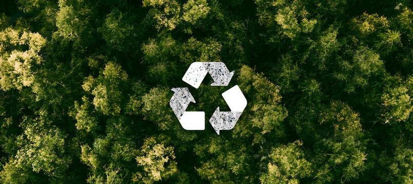 Aerial view of a recycling symbol in a lush green forest