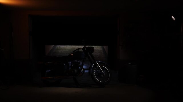 Motorcycle standing inside a dark garage with its automatic door slowly opening, revealing a path forward and symbolizing new opportunities, freedom, or escape