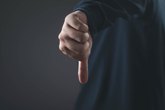 Dislike and negative feedback concept with hand showing thumbs down gesture, representing rejection, dissatisfaction, poor review, failure, criticism, disagreement and customer opinion.