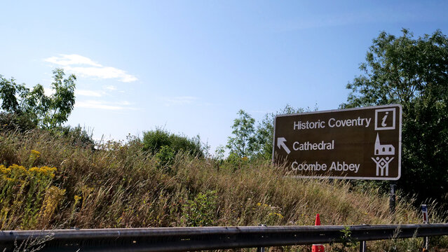 Brown tourist road sign, direction sign, British highway signage pointing to Historic Coventry, Cathedral, and Coombe Abbey