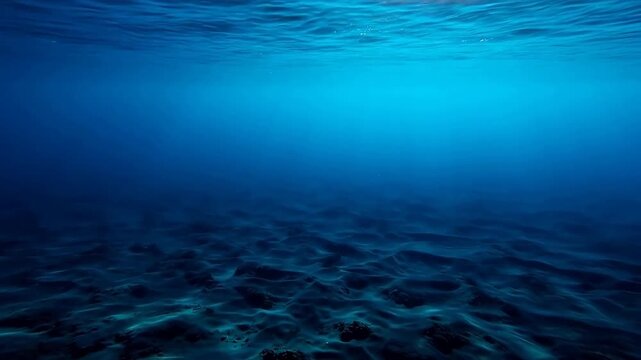 Underwater ocean scene with sandy seabed and sunlight filtering through water surface