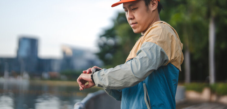 Adult man runner checking smartwatch tracking monitor after workout marathon training