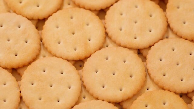 Macro shot of round salty cracker cookies. Snacks. Beer snack. Smooth rotation in a circle	
