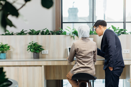 Young business muslim woman and business man colleague talking and meeting discussing at the modern office