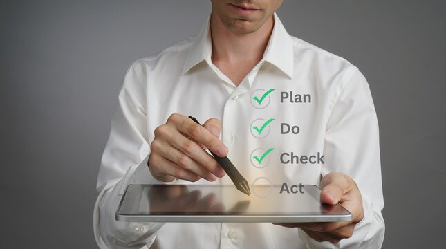 Businessman using a digital tablet to manage professional workflow tasks with a Plan Do Check Act cycle methodology