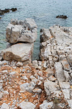 Limestone coastal rocks covered with orange lichens overlooking the Adriatic Sea on Dugi Otok, Croatia