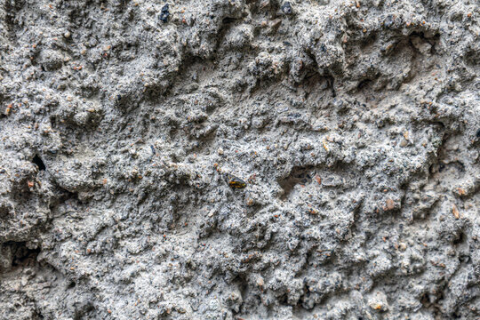 Rough textured concrete surface with embedded aggregate and weathered patches